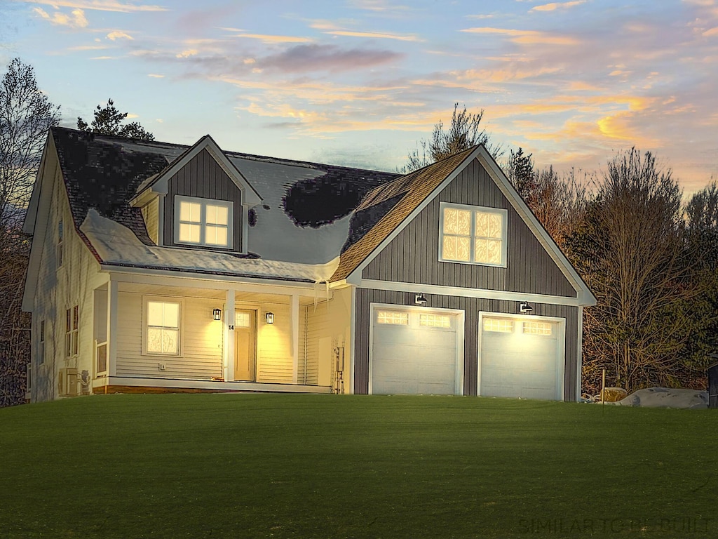 back of house at dusk with covered porch, a lawn, and a garage