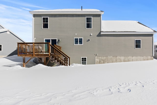 snow covered house featuring a wooden deck