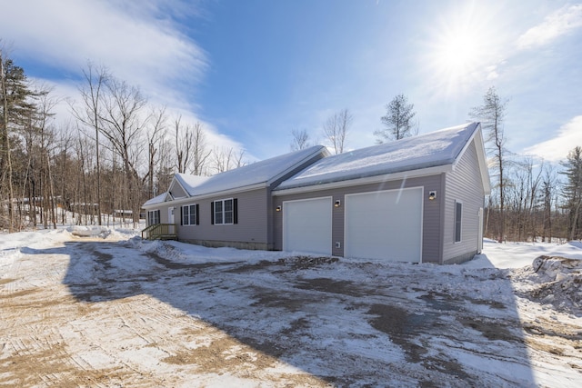 view of snowy exterior featuring an attached garage