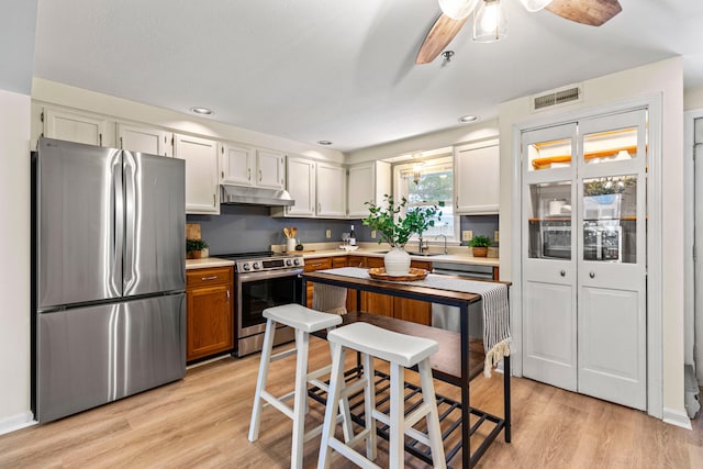 kitchen featuring appliances with stainless steel finishes, sink, light hardwood / wood-style floors, and white cabinetry