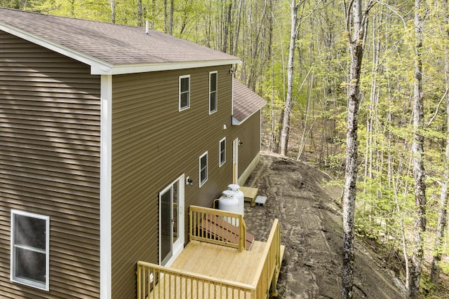 232 Bond Spring Rd, Newfield, ME 04095 - view of side of home with roof with shingles, a view of trees, and a wooden deck