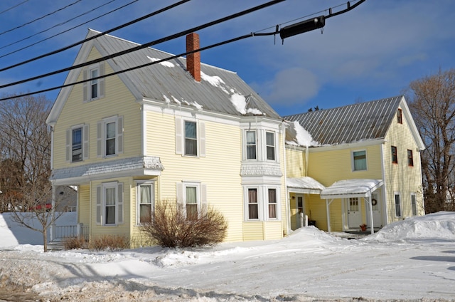 view of front of house with metal roof and a chimney