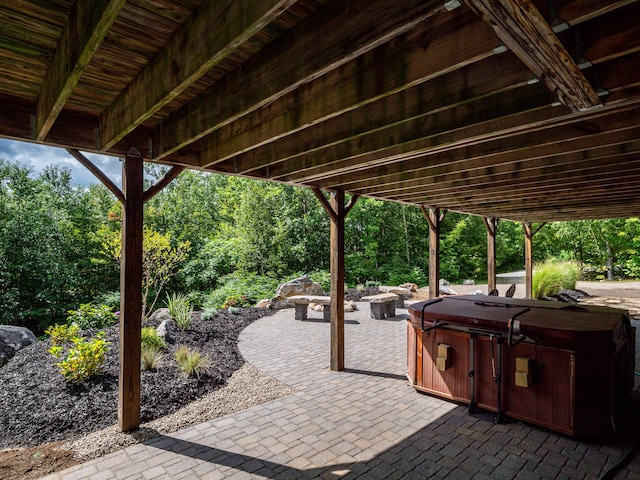 view of patio / terrace with a hot tub and an outdoor fire pit