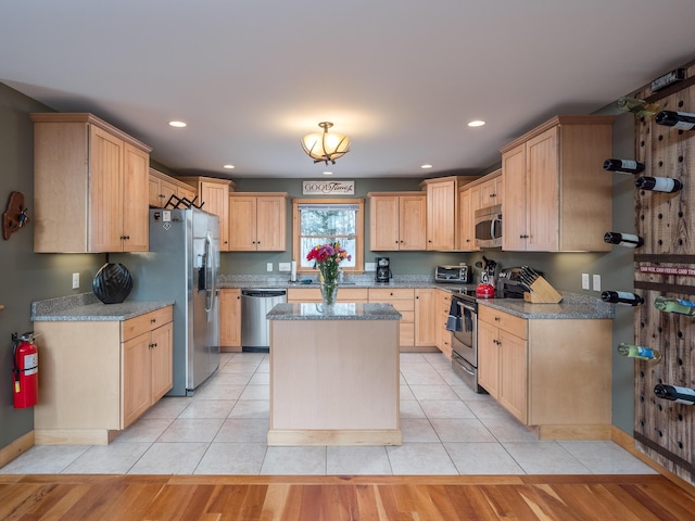 kitchen featuring appliances with stainless steel finishes, light tile patterned floors, light stone counters, and light brown cabinets