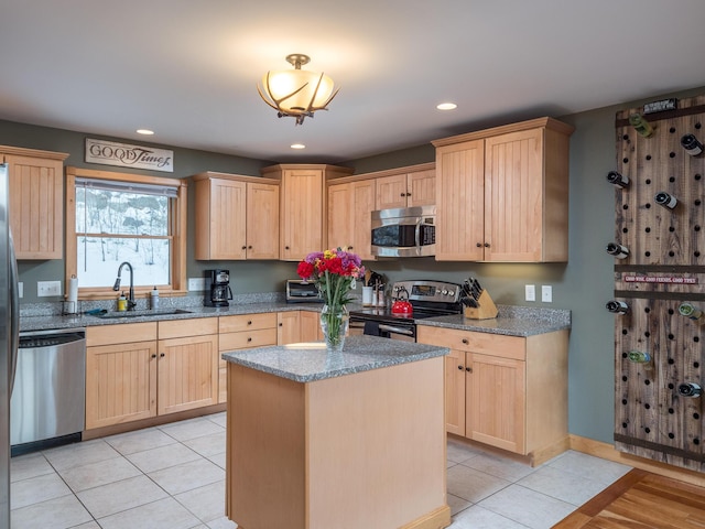 kitchen featuring appliances with stainless steel finishes, a kitchen island, sink, and light brown cabinets