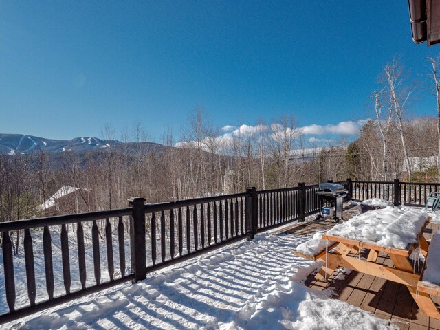 snow covered deck with a mountain view