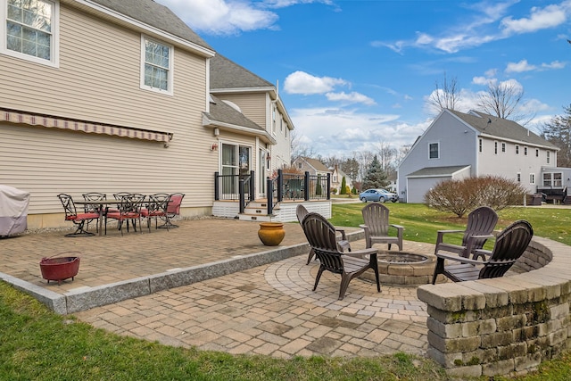 view of patio featuring a grill, a residential view, a fire pit, and outdoor dining space