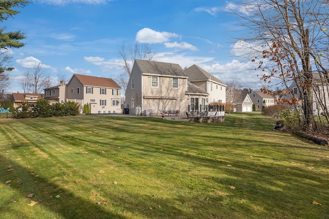 back of house with a residential view and a lawn