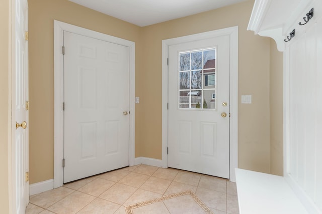 doorway featuring baseboards and light tile patterned flooring