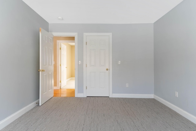 empty room with light carpet and baseboards