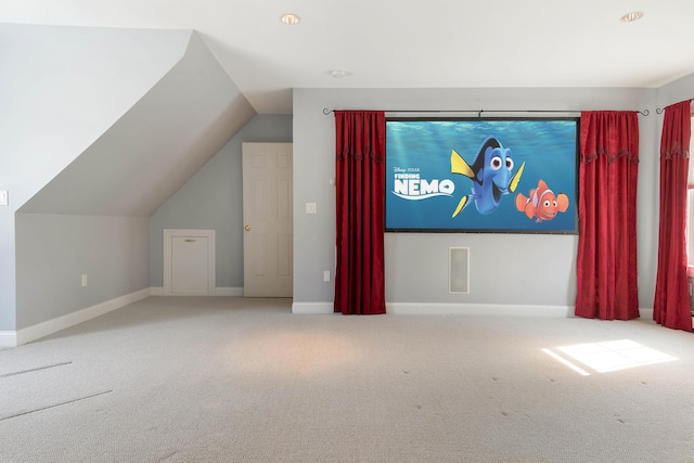 cinema room featuring carpet floors, lofted ceiling, and baseboards