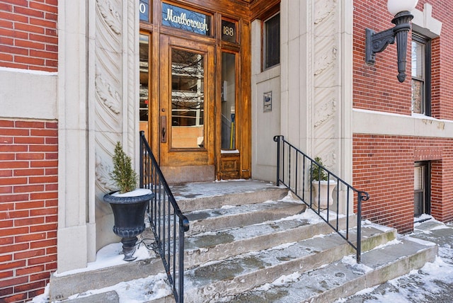 doorway to property featuring brick siding