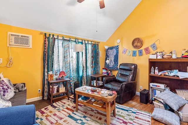 interior space with baseboards, a wall mounted air conditioner, lofted ceiling, wood finished floors, and a ceiling fan