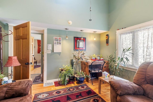 living room with hardwood / wood-style flooring and a towering ceiling