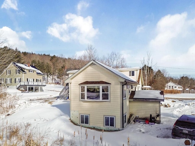 view of snow covered back of property