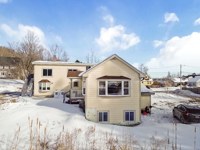 view of snow covered rear of property