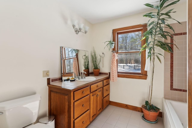 bathroom with toilet, tile patterned flooring, baseboards, and vanity