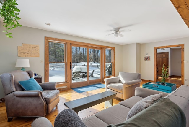 living area featuring light wood-type flooring and a ceiling fan