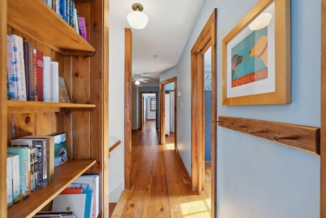 corridor featuring baseboards and light wood-style floors