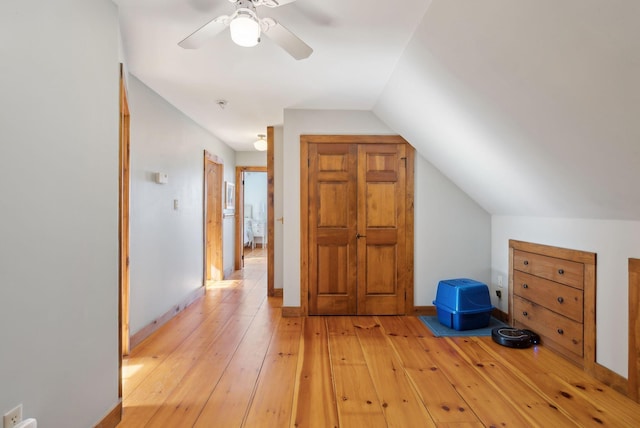 additional living space featuring light wood-type flooring, ceiling fan, baseboards, and vaulted ceiling