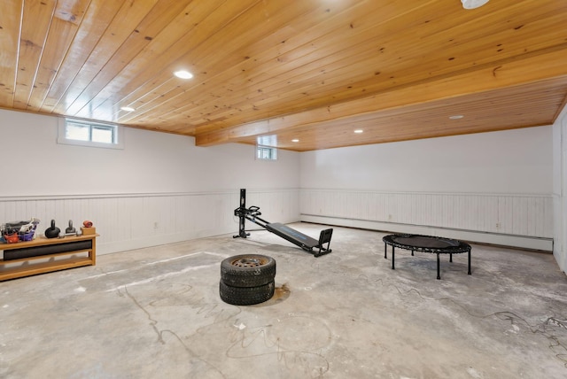 workout area featuring wood ceiling, a wainscoted wall, and baseboard heating