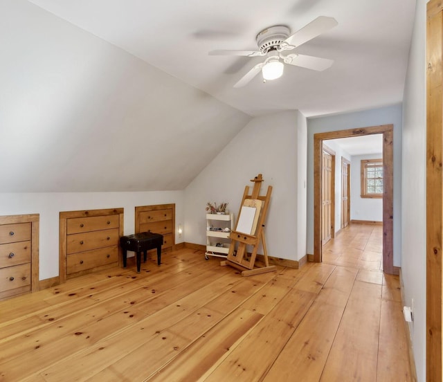 bonus room with lofted ceiling, light wood finished floors, baseboards, and a ceiling fan