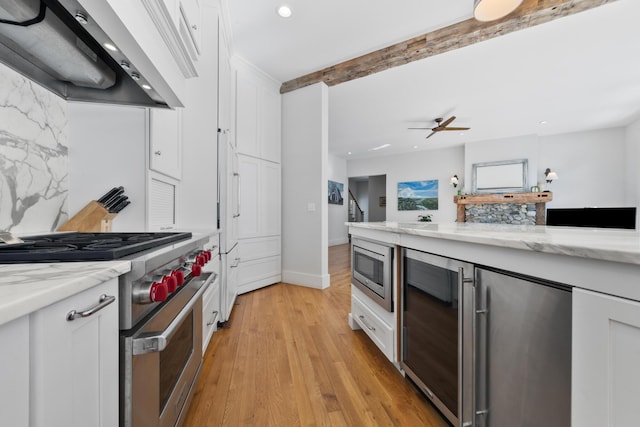 kitchen featuring premium range hood, white cabinetry, and stainless steel appliances