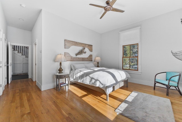 bedroom with ceiling fan, baseboards, and wood finished floors