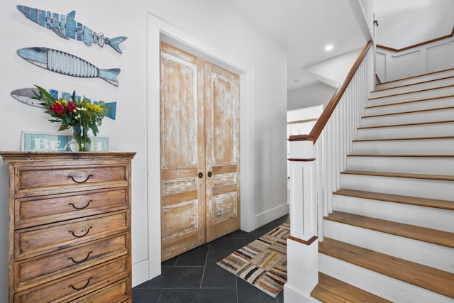 foyer featuring recessed lighting, french doors, dark tile patterned floors, and stairs