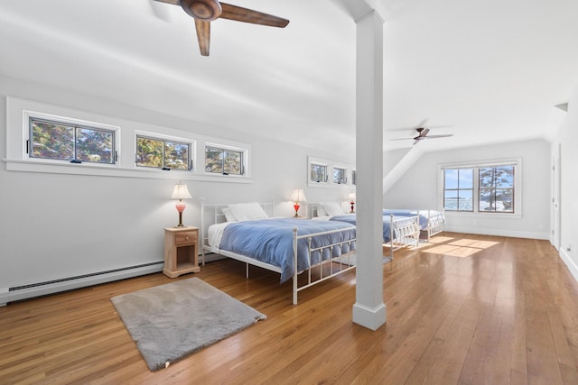 bedroom featuring baseboards, a ceiling fan, vaulted ceiling, light wood-style floors, and a baseboard heating unit