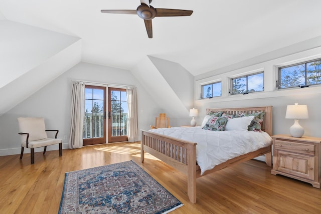 bedroom with light wood-style flooring, baseboards, vaulted ceiling, and a ceiling fan