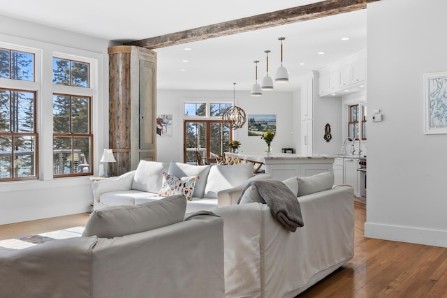 living room with light wood-style flooring, baseboards, a chandelier, and recessed lighting