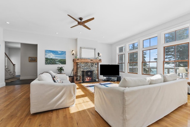 living room featuring stairway, a fireplace, and light wood-style flooring