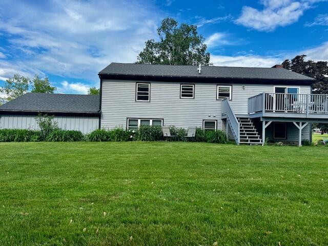 back of house featuring stairs, a lawn, and a wooden deck