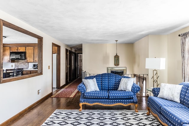 living area featuring baseboards and dark wood-style flooring