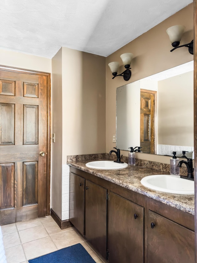 bathroom with double vanity, a sink, and tile patterned floors