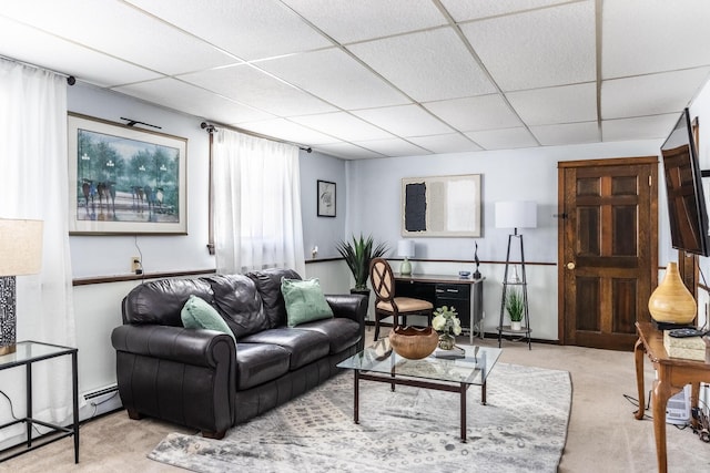 living area with a baseboard heating unit, a paneled ceiling, and light colored carpet