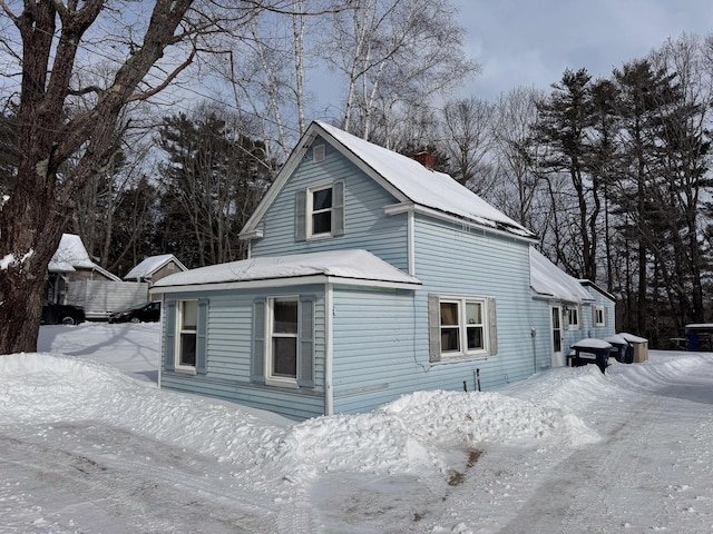 snow covered property with a chimney