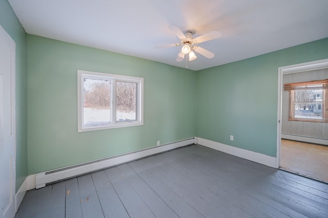 spare room with a healthy amount of sunlight, a baseboard radiator, and wood finished floors