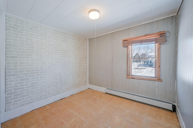 empty room with a baseboard radiator and brick wall