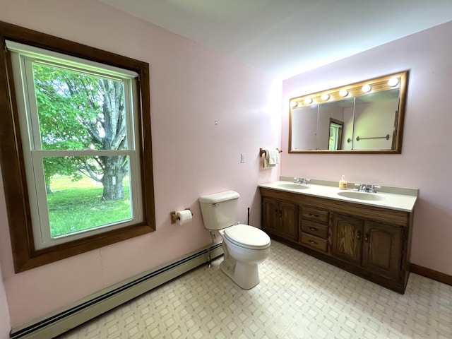 96 Exeter Rd, Garland, ME 04939 - bathroom featuring a baseboard radiator, double vanity, toilet, and baseboards