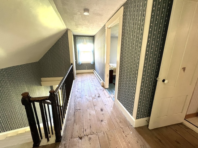 96 Exeter Rd, Garland, ME 04939 - hallway with hardwood / wood-style floors, wallpapered walls, baseboards, an upstairs landing, and a baseboard heating unit