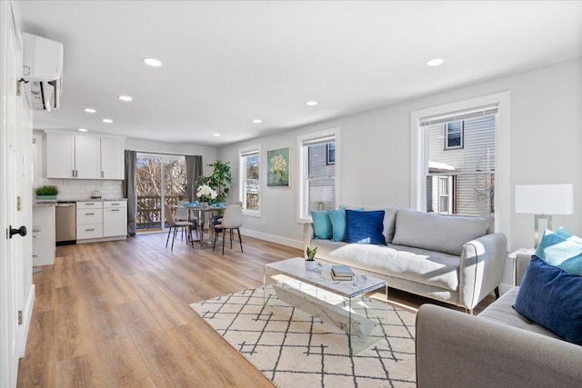 living room featuring light wood-style flooring, baseboards, and recessed lighting