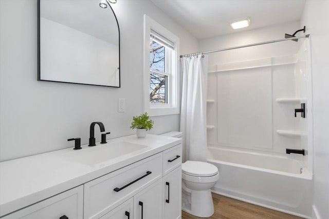 full bathroom with toilet, shower / bathtub combination with curtain, wood finished floors, and vanity