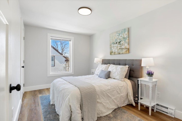 bedroom featuring a baseboard radiator, wood finished floors, and baseboards