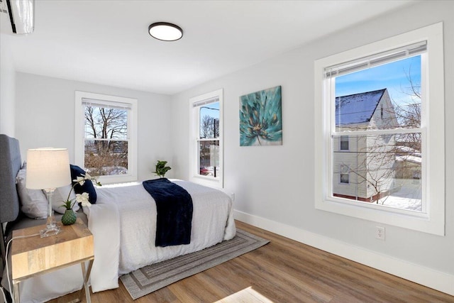 bedroom featuring wood finished floors and baseboards