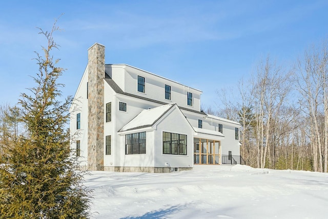 snow covered property with a chimney