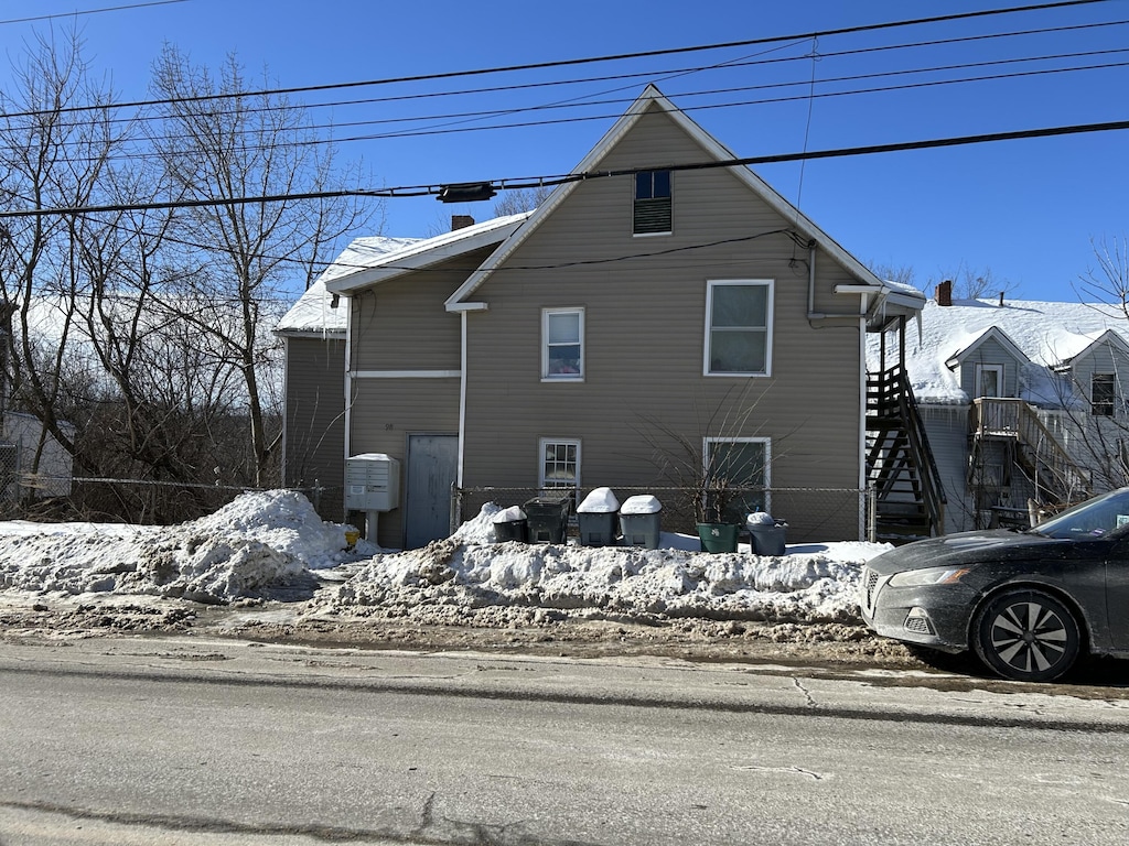 snow covered property with stairs