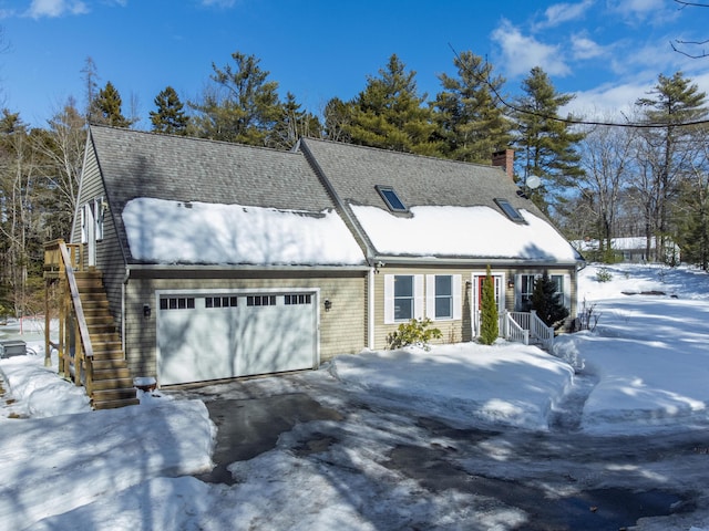 view of front of home featuring an attached garage, driveway, a chimney, and roof with shingles