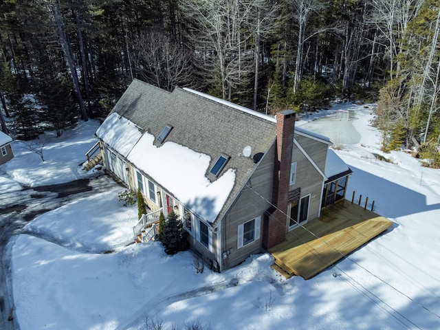 snowy aerial view featuring a wooded view